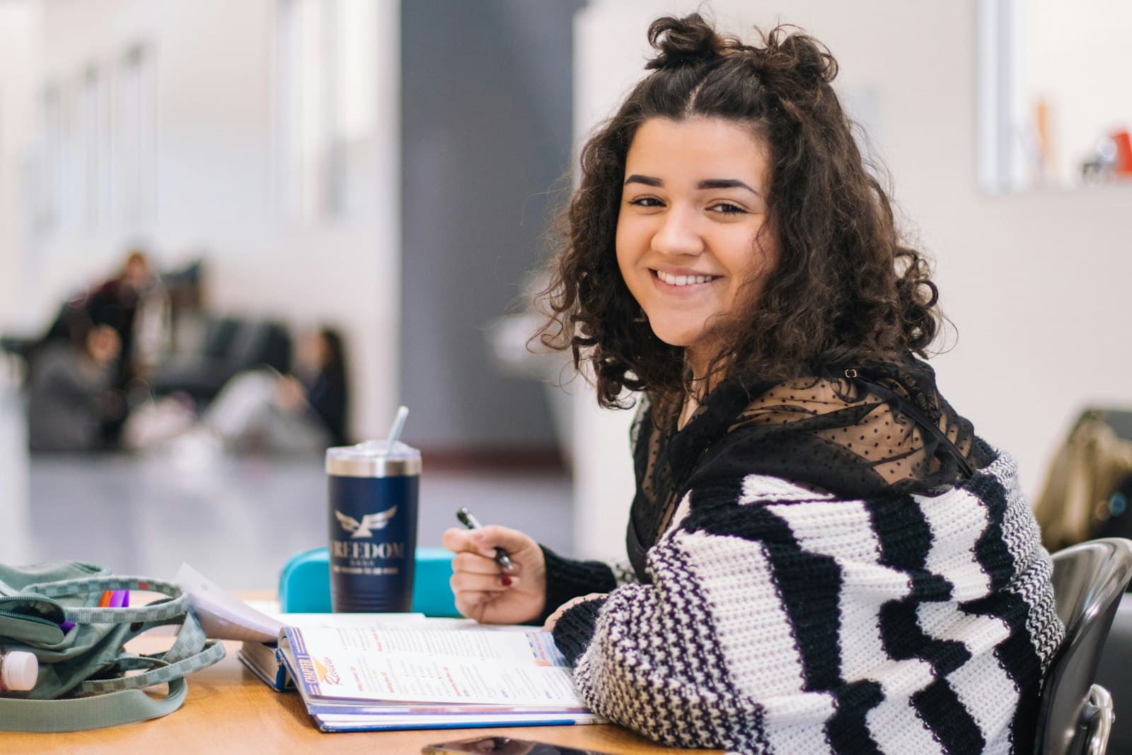 A smiling student looking up from her notes